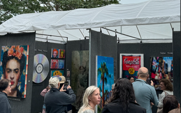 Capturing an image of an optical-illusion art booth at The 60th Annual Coconut Grove Art Festival, visitors enjoy the last day of a weekend full of art, entertainment and good food. 